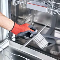 Ręka w czerwonej rękawicy wyjmuje filtr zmywarki Bosch. Może to być przyczyną, że zmywarka Bosch nie pobiera wody.