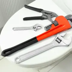 Narzędzia do hydrauliki na desce sedesowej. Klucze i kombinerki, które pomogą Ci dowiedzieć się, jak naprawić deskę wolnoopadającą.