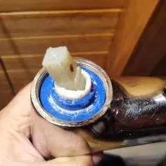 Wymiana głowicy w baterii prysznicowej. Widoczny element ceramiczny i mechanizm do regulacji wody.