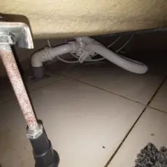 Podczas wymiany syfonu w wannie zabudowanej, widać instalację hydrauliczną pod wanną i odpływ.