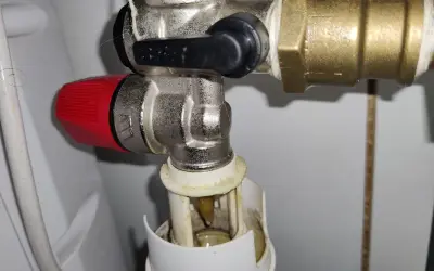Zawór z czerwoną rączką, w którą stronę odkręca się zawór wody, jest skierowany w lewo.