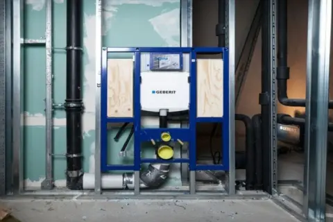 Montaż stelaża Geberit z podłączeniem do odpływu. Instalacja hydrauliczna w trakcie budowy.