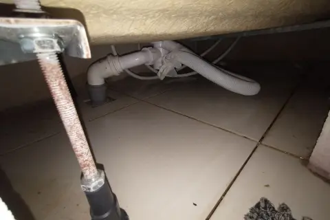 Podczas wymiany syfonu w wannie zabudowanej, widać instalację hydrauliczną pod wanną i odpływ.