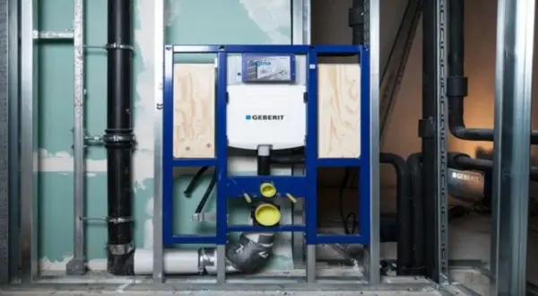 Montaż stelaża Geberit z podłączeniem do odpływu. Instalacja hydrauliczna w trakcie budowy.