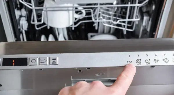 Palec wskazuje przycisk "Eco" na panelu zmywarki Gorenje, która wyświetla błąd F12.