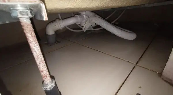 Podczas wymiany syfonu w wannie zabudowanej, widać instalację hydrauliczną pod wanną i odpływ.