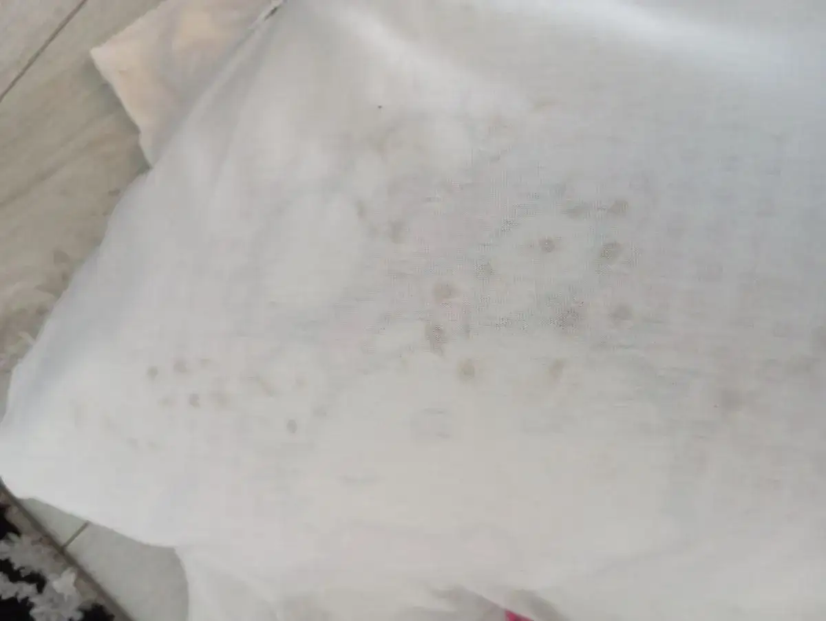 Biała koszulka z plamami, jakby pralka brudzi białe ubrania.